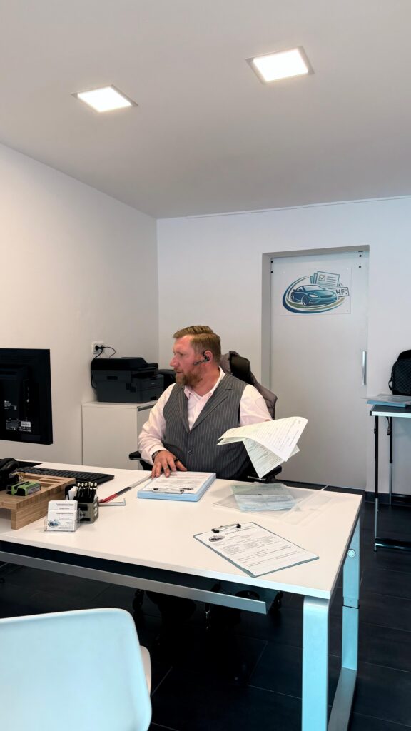 Bürobild mit Person die am Schreibtisch arbeitet