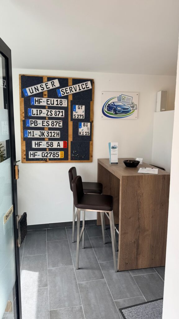 Bürobild mit Kennzeichen an der Wand und einem hohen Tisch