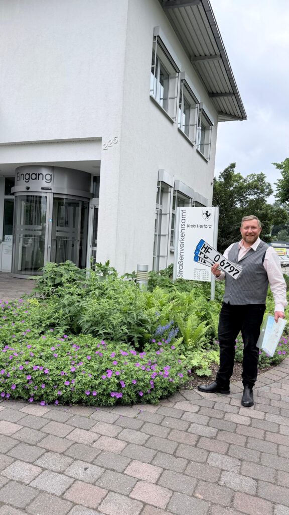 Bild von Person mit Kennzeichen in der Hand
